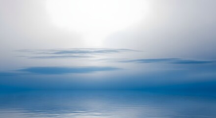 Obraz premium Serene ocean horizon with soft sunlight breaking through foggy clouds