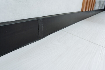 Explore the appeal of sleek black baseboard trim that enhances modern interiors, adding...