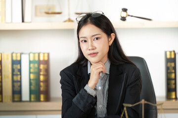 Confident Lawyer. Young female lawyer posing thoughtfully in office with gavel.