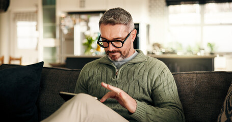 Fototapeta premium Tablet, remote work and mature man in home to review news, article or report online. Technology, journalist and freelancer in living room to check email for headline, story and research on internet