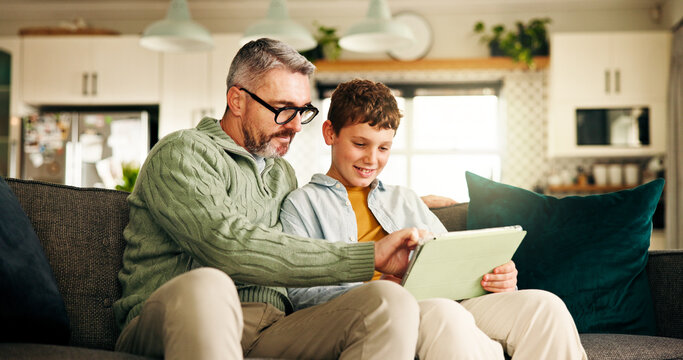 Home, father and son with tablet, help and bonding together with online game, entertainment and smile. Learning, family and dad on couch, boy and parent with technology, social media and digital app - Powered by Adobe