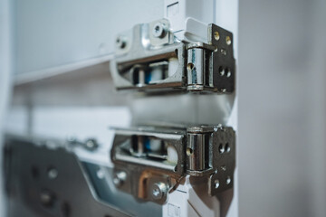 This is a closeup view featuring highquality metal door hinges attached to a stylish modern cabinet, showcasing the intricate details and craftsmanship involved in their design and functionality