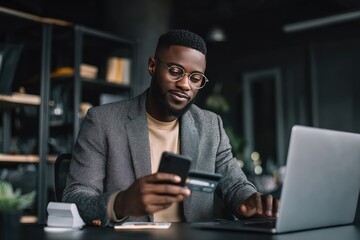 Man in business attire using laptop and phone for online payment