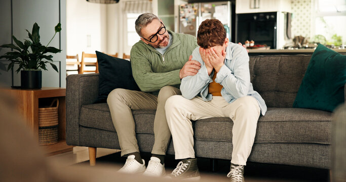 Comfort, consoling and crying son with father on sofa in living room of home for empathy or support. Emotions, love and sad boy child with single parent man in apartment for trust or understanding