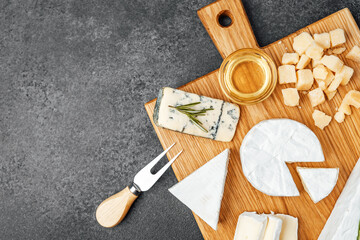 Gourmet cheese selection with accompaniments on a wooden board