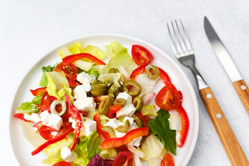 Closeup lettuce salad with tomato red pepper feta and olives concept for healthy diet or gourmet restaurant photography