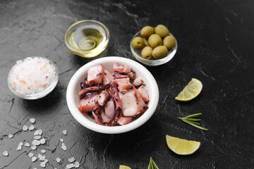 Octopus with olives, oil and salt on black background for gourmet ingredient or rustic cooking concept