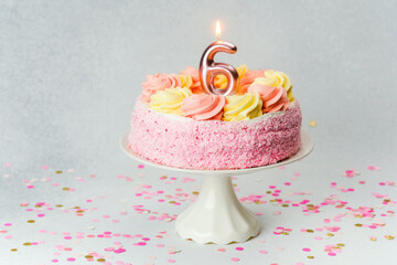 Celebration of a child's sixth birthday with a decorated cake and confetti