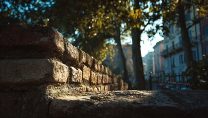 Fototapeta premium Rustic brick wall, sunlight filters through trees, urban backdrop