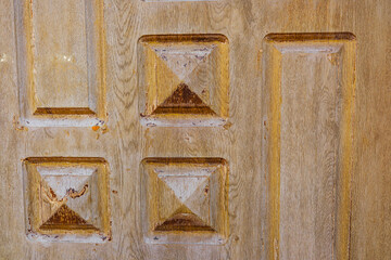 Rustic wood paneling with carved squares and weathered texture