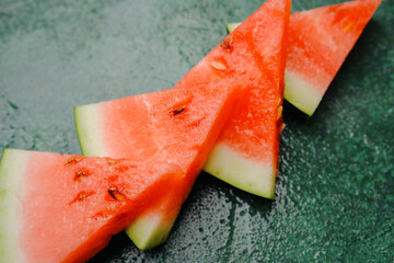 slice of watermelon on a dark green background