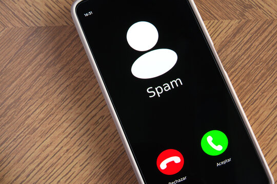 Incoming spam call on mobile phone on table