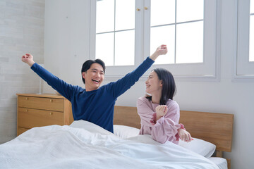 起床したベッドの上の夫婦