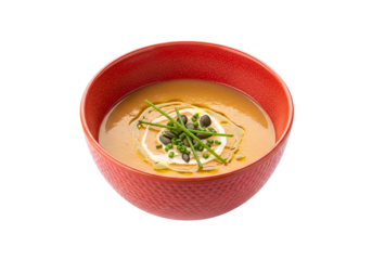 A vibrant, textured bowl of smooth, warm soup, featuring a rich orange hue and garnished with fresh chives, pumpkin seeds, and a dollop of creamy topping.