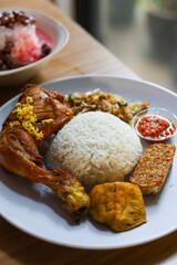 rice with fried chicken and vegetable salad (trancam) and chili sambal.