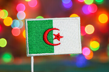 Algeria embroidered flag with colorful bokeh fireworks background, symbolizing national pride , New...