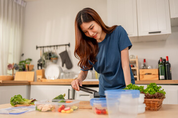 Asian young woman cooking healthy foods in kitchen in morning at home. 