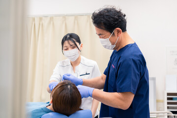 Obraz premium 歯科治療をする歯医者の男性