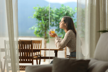 Woman smelling tea aroma in a terrace at home