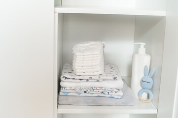 Organized baby wardrobe with clothes, toys and diapers