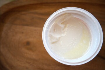 Close-up of sour cream in an open plastic container, isolated for food and dairy concepts.
