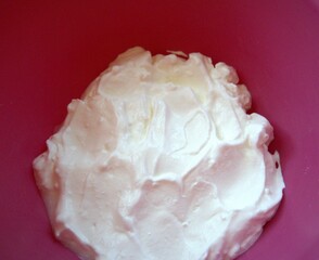 Close-up of sour cream served in a pink bowl with copy space, ideal for culinary or recipe use.
