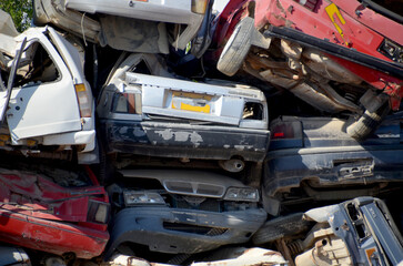 
Stacked old and wrecked cars in a junkyard.

A close-up, horizontal view of a pile of old,...
