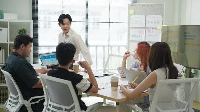 In a modern office interior, Asian business friends brainstorm a strategic growth plan. Through a hackathon and analysis, they aim to predict and summarize future business success.	