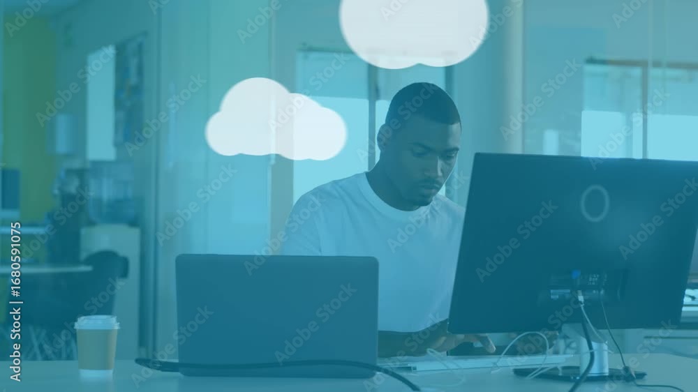 Aufkleber animation of graphical clouds and computer icons over african american businessman using computer