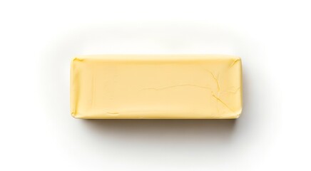 A single stick of butter, wrapped in light yellow paper, isolated on a white background.