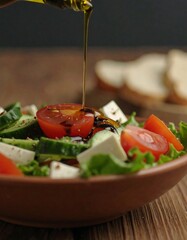 Fresh salad being dressed with oil