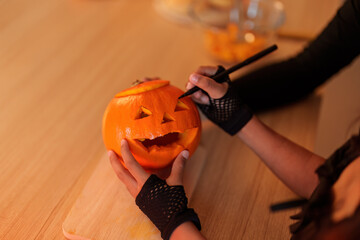 Halloween Pumpkin Carving. Child creating spooky jack-o'-lantern with adult supervision.