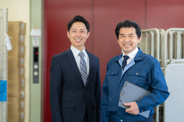 倉庫で商談をする社長とビジネスマン