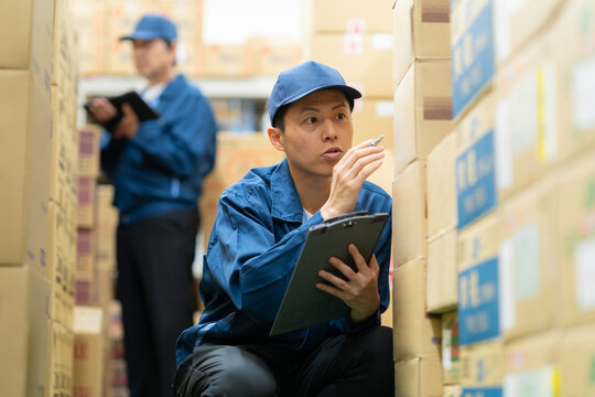 倉庫で打ち合わせをするミドルの作業員 - Powered by Adobe