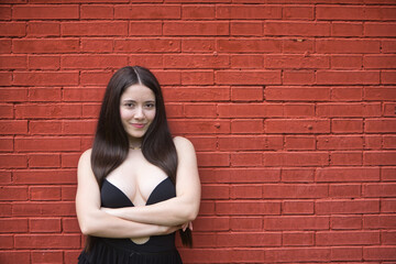 Portrait of a young brunette woman, beautiful, with pale skin, wearing a black dress, smiling and...