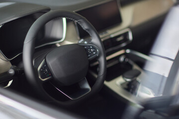 Closeup of a modern car steering wheel with control buttons for technology and convenience