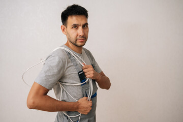Portrait of electrician male wearing gray overall holding bunch of electrical wires while working...