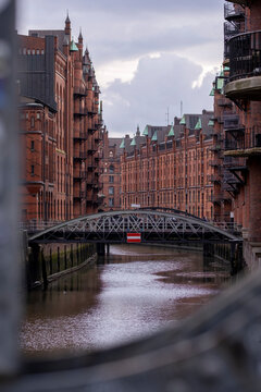 Historic Speicherstadt canal in Hamburg, Germany, with red brick warehouses and iron bridges, UNESCO World Heritage Site symbolizing industrial heritage and cultural urban identity