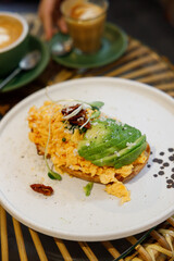 Delicious healthy breakfast plate, sourdough sandwich with scrambled eggs and avocado.