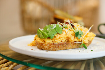 Delicious healthy breakfast plate, sourdough sandwich with scrambled eggs and avocado.