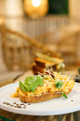 Delicious healthy breakfast plate, sourdough sandwich with scrambled eggs and avocado.