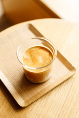 Cup of milk dirty coffee on table by the window.