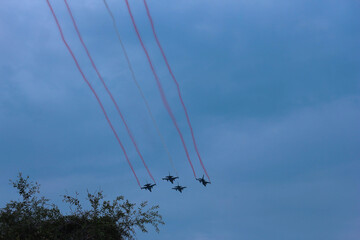 Silhouettes of four fighter planes with smoke in airshow