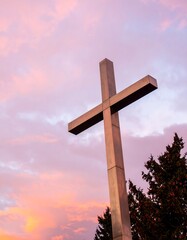 Metal cross against a vibrant sunset sky