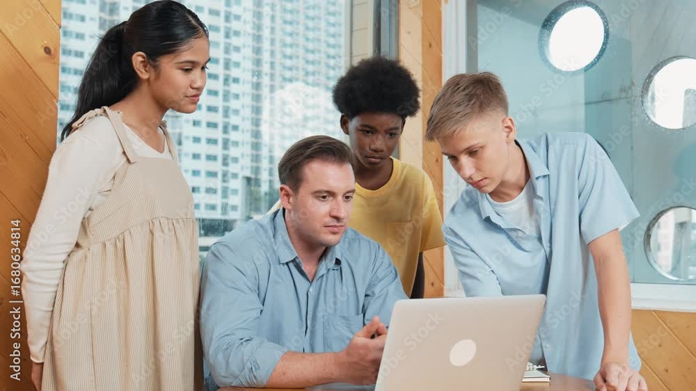 Poster high school boy presenting project while teacher looking at laptop. Group of diverse student standing and explain plan while smart instructor listening and giving advise.Teamwork concept. Edification