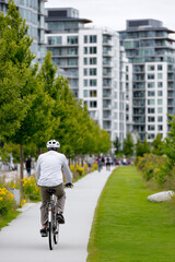 Naklejka premium Person cycling on a green path in an eco-friendly city