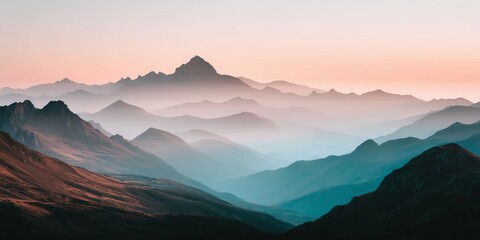 Obraz premium Beautiful misty mountain landscape at sunrise with pastel sky and layered peaks.