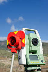 Survey equipment stands against a mountain backdrop, vital for construction site layout and...