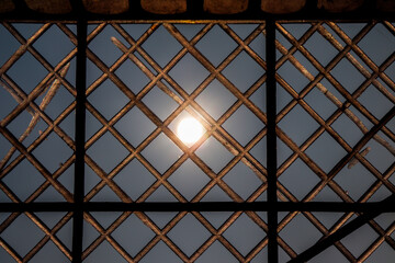 Bright Sun Shining Through Lattice Window Creating Geometric Patterns and Shadows