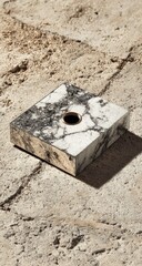 Square, white marble pen holder on light beige stone